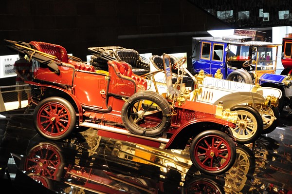 Shiny vintage Mercedes-Benz car on display with striking red rims and reflections, Mercedes-Benz Museum, Stuttgart, Baden-Wuerttemberg, Germany, Europe