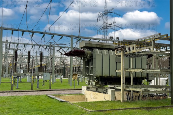 Substation substation part of electrical supply network with transformer generator in the background high-voltage lines high-voltage pylon for secure power supply power supply, above blue sky with white clouds Altocumulus, Germany, Europe