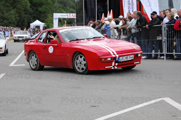 A red classic sports car takes part in a vintage car race, surrounded by spectators, SOLITUDE REVIVAL 2011, Stuttgart, Baden-Wuerttemberg, Germany, Europe
