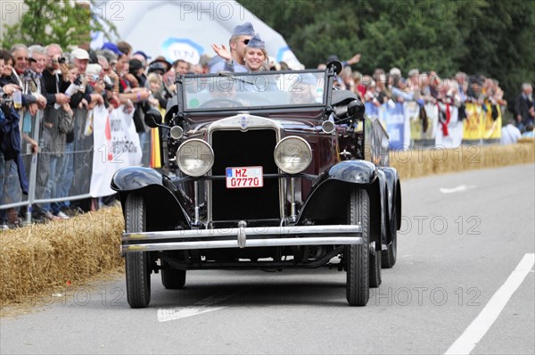 Dark antique car in a parade with passenger waving to the crowd, SOLITUDE REVIVAL 2011, Stuttgart, Baden-Wuerttemberg, Germany, Europe