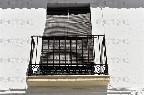Solabrena, blinds protect a balcony window on a white building from the intense sun, Andalusia, Spain, Europe