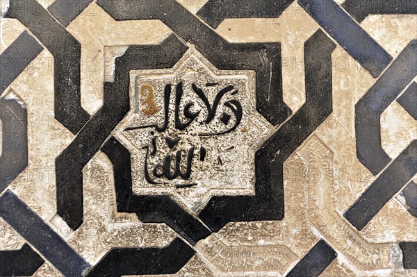 Artistic stone carvings, Alhambra, Granada, A mosaic with Islamic calligraphy in black and white on a floor tile, Granada, Andalusia, Spain, Europe