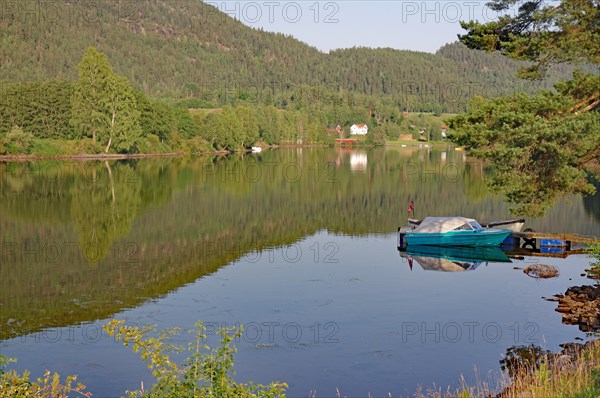 Trees and a small boat are reflected in a calm lake, old waterway, Telemark Canal, Telemark, Norway, Europe