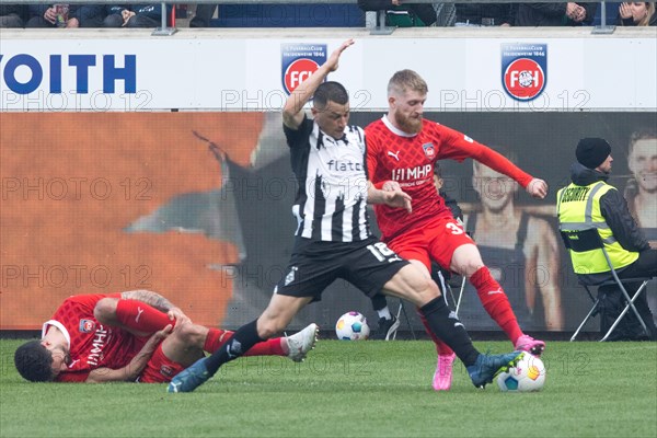 Football match, Stefan LAINER Borussia Moenchengladbach left fighting for the ball with Jan-Niklas BESTE 1.FC Heidenheim while Tim KLEINDIENST 1.FC Heidenheim rolls on the ground after a foul, Voith-Arena football stadium, Heidenheim