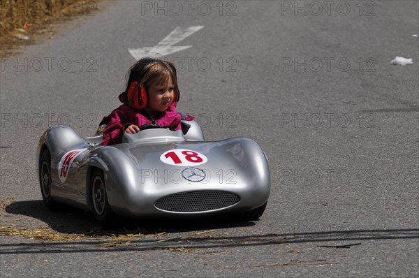 A small child concentrates while driving a silver soapbox with the number 18, SOLITUDE REVIVAL 2011, Stuttgart, Baden-Wuerttemberg, Germany, Europe