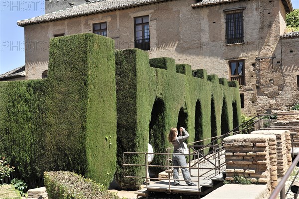 Patio de Machuca, Alhambra, Granada, Garden path with dense green hedges and two people in the background, Granada, Andalusia, Spain, Europe