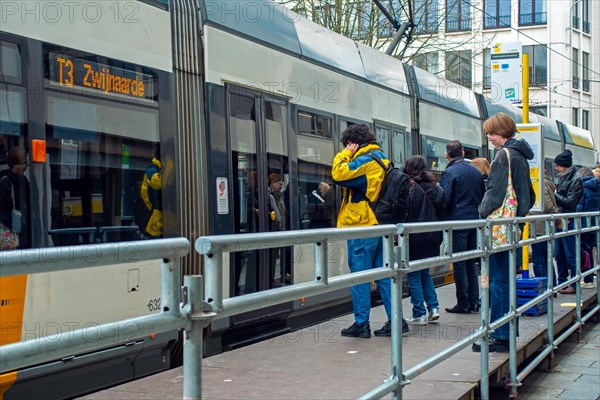 Commuters and shoppers boarding tram at tramstop of the Flemish transport company De Lijn in the city centre of Ghent, East Flanders, Belgium, Europe