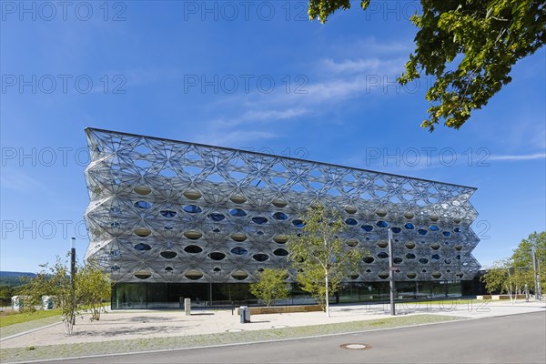Reutlingen University, Reutlingen University, Texoversum, German University Building Award 2024 for TEXOVERSUM, modern architecture, facade made of carbon and glass fibres, mesh, innovative, identity-creating, unique facade, campus, place of learning, special, extraordinary new building for textile courses, light, airy, airy, holes, architectural eye-catcher, university campus, lights, street, young trees, blue sky, Reutlingen, Baden-Wuerttemberg, Germany, Europe