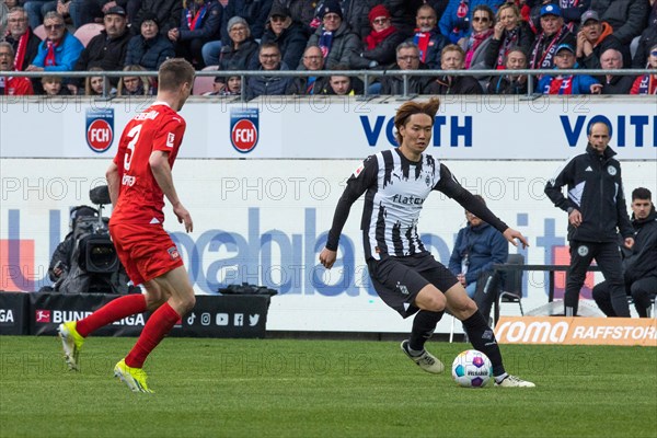 Football match, Ko ITAKURA Borussia Moenchengladbach right on the ball, Jan SCHOePPNER 1.FC Heidenheim left tries to stop him, football stadium Voith-Arena, Heidenheim