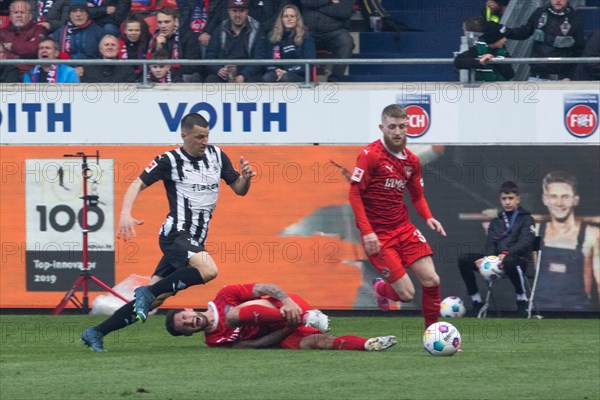 Football match, Stefan LAINER Borussia Moenchengladbach left pursues Jan-Niklas BESTE 1.FC Heidenheim while Tim KLEINDIENST 1.FC Heidenheim rolls on the ground after a foul, football stadium Voith-Arena, Heidenheim