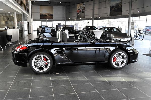 A black Porsche Cabriolet with an open roof stands in the showroom, Schwaebisch Gmuend, Baden-Wuerttemberg, Germany, Europe