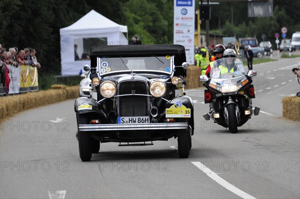 A black vintage car at a racing event escorted by a police motorbike, SOLITUDE REVIVAL 2011, Stuttgart, Baden-Wuerttemberg, Germany, Europe