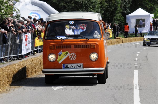 An orange Volkswagen bus drives past a crowd at a race, SOLITUDE REVIVAL 2011, Stuttgart, Baden-Wuerttemberg, Germany, Europe