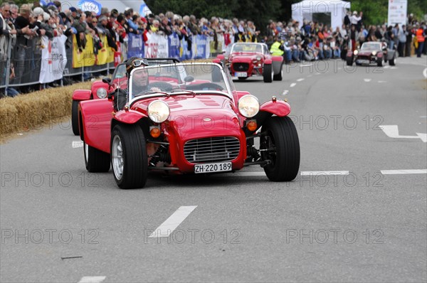 A red vintage sports car drives through a crowd at a street race, SOLITUDE REVIVAL 2011, Stuttgart, Baden-Wuerttemberg, Germany, Europe