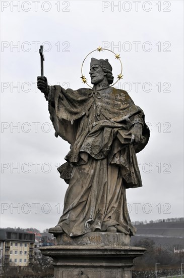 The bridge saint Johannes von Nepomuk, old Main bridge, Wuerzburg, statue of a saint with nimbus and raised arm, city in the background, Wuerzburg, Lower Franconia, Bavaria, Germany, Europe