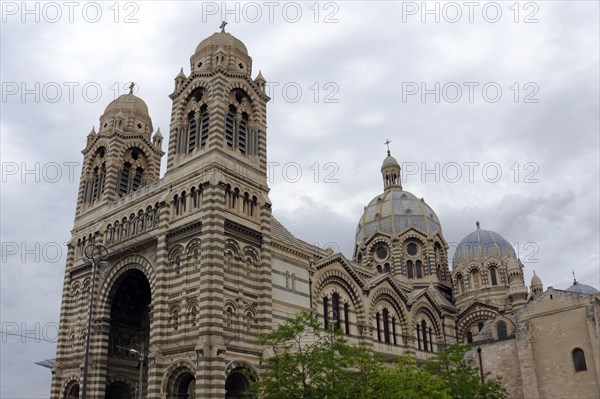 Marseille Cathedral or Cathedrale Sainte-Marie-Majeure de Marseille, 1852-1896, Marseille, Front view of the facade of a double-domed cathedral against a blue sky, The church with twin bell towers under a cloudy sky, Marseille, Departement Bouches-du-Rhone, Provence-Alpes-Cote d'Azur region, France, Europe