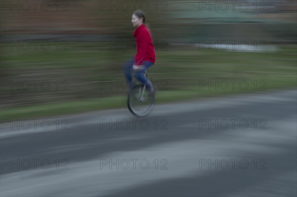 Girl, 10 years old, riding a unicycle, motion blur, Mecklenburg-Vorpommern, Germany, Europe