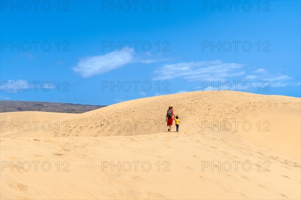 (Varios valores) Mother and son walking in the dunes of Maspalomas on vacation, Gran Canaria, Canary Islands