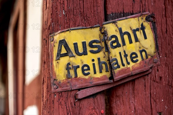 Old sign, keep exit clear, bent and rusty on wooden beam, courtyard exit, historic half-timbered house, old town, Ortenberg, Vogelsberg, Wetterau, Hesse, Germany, Europe