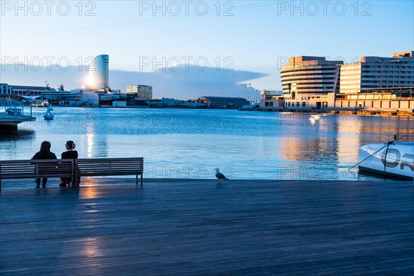 Two people sitting at the old harbour in Barcelona, Spain, Europe