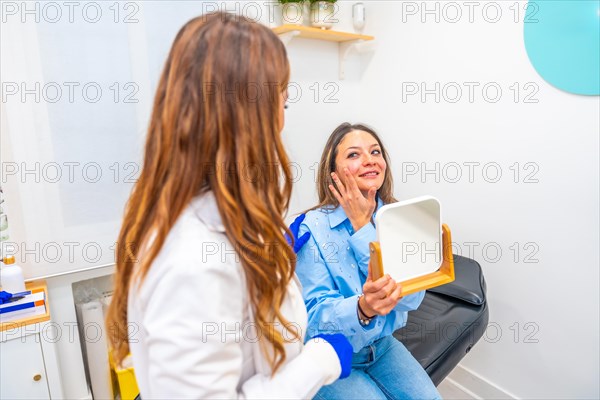 Satisfied woman talking to doctor after beauty treatment applying hyaluronic acid injection on lips in a clinic