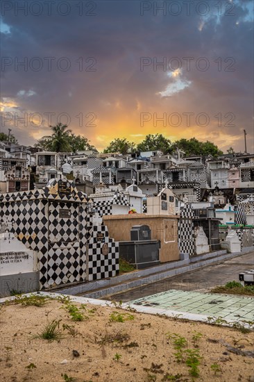 Famous cemetery, many mausoleums or large tombs decorated with tiles, often in black and white. Densely built buildings under a sunset Cimetiere de Morne-a-l'eau, Grand Terre, Guadeloupe, Caribbean, North America