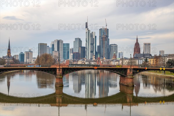 Sunrise on a riverbank in the centre of a big city. Spring with a view of the skyline of the banking district and the historic buildings of Frankfurt, Hesse