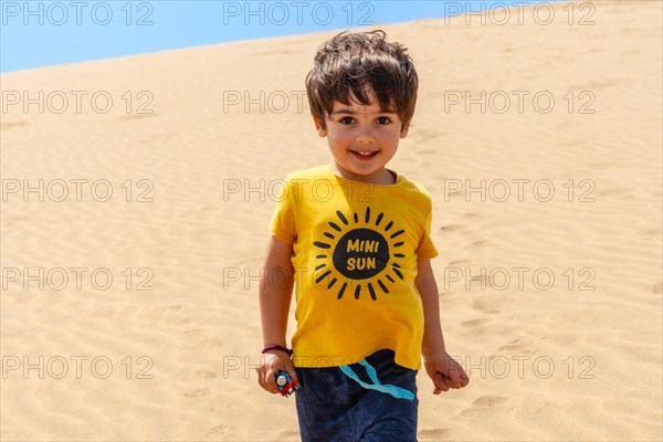 Portrait of tourist boy walking in the dunes of Maspalomas, Gran Canaria, Canary Islands