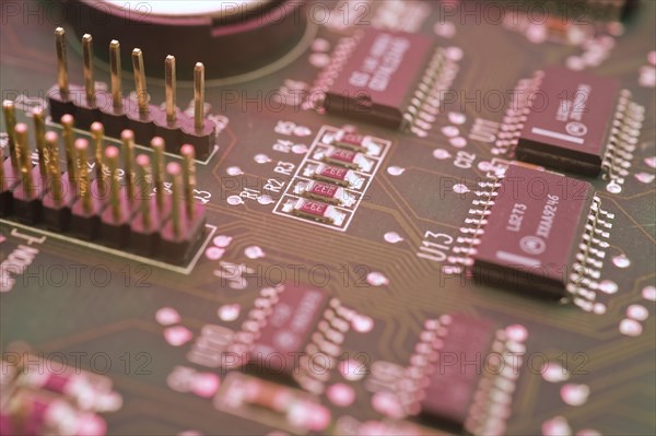 Close-up of pinkish lighted electronic computer circuit board, microchips, silver solder points and lines, Studio Composition, Quebec, Canada, North America