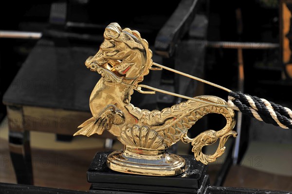 Close-up of a shiny golden seahorse figure on a Venetian gondola, Venice, Veneto, Italy, Europe