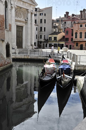 Two gondolas rest in the clear waters of a canal, surrounded by traditional Venetian architecture, Venice, Veneto, Italy, Europe