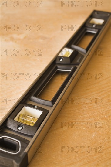 Close-up of black plastic and aluminum spirit level tool on plywood floor background, Studio Composition, Quebec, Canada, North America