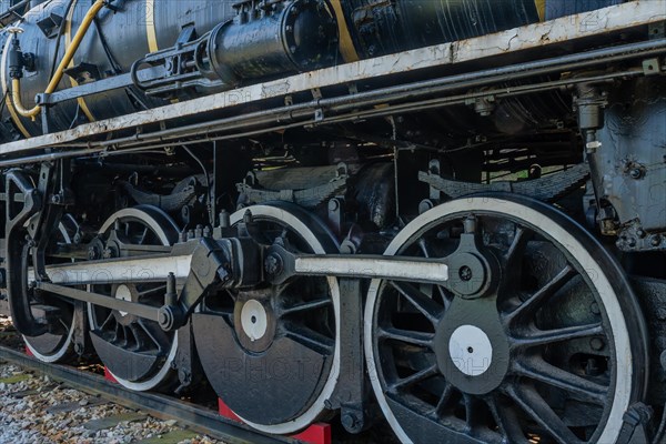 Side view of a black locomotive showing the complex mechanical details of wheels and parts, in South Korea