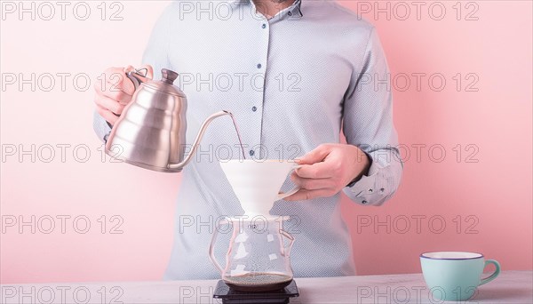 Focused individual manually brewing pour-over coffee with a pink background, horizontal, AI generated
