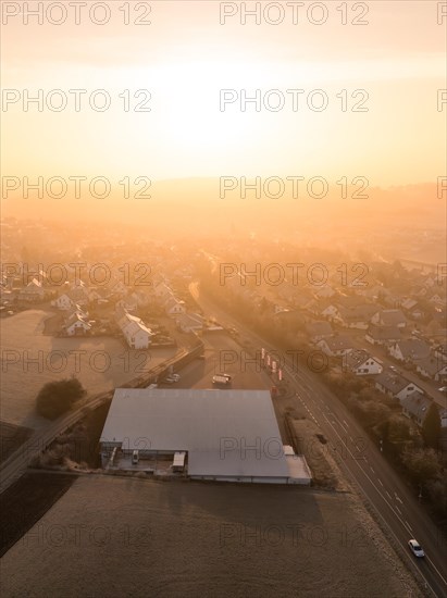 First rays of sunlight illuminate an industrial area seen from above, Gechingen, Black Forest, Germany, Europe