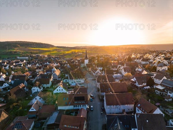 Village wrapped in the golden light of dusk with vast fields in the background, Calw, Black Forest, Germany, Europe
