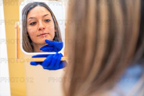 Reflection on a mirror of a woman looking herself before start a plastic surgery