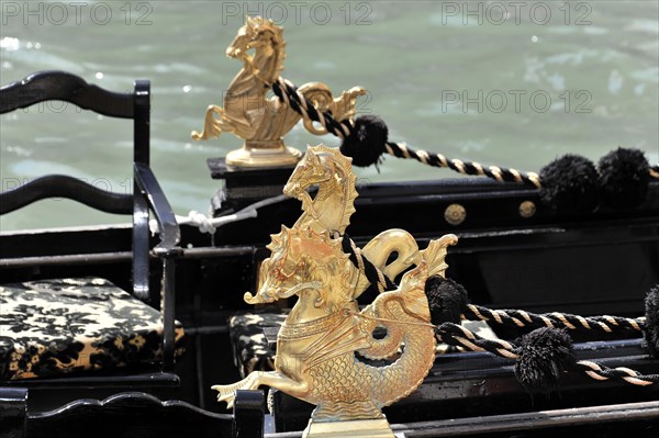 Close-up of a shiny golden dragon figure at the top of a Venetian gondola, Venice, Veneto, Italy, Europe