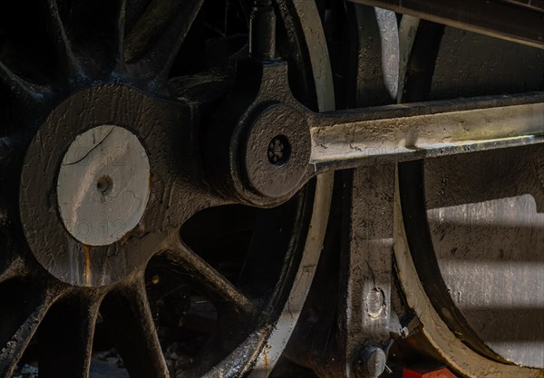 Close-up of a vintage train wheel showing intricate metalwork and interplay of shadow and light, in South Korea