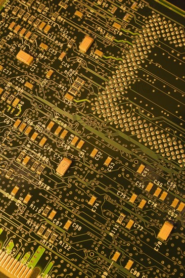Close-up of dark green and golden yellow lighted electronic computer circuit board with lines and silver solder points, Studio Composition, Quebec, Canada, North America