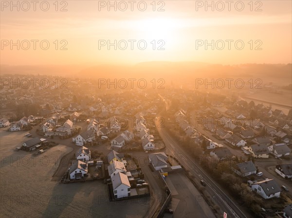 The sunrise bathes a small town in a warming golden light, Gechingen, Black Forest, Germany, Europe