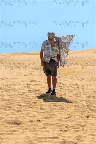 Tourist man with turban in summer in the dunes of Maspalomas, Gran Canaria, Canary Islands