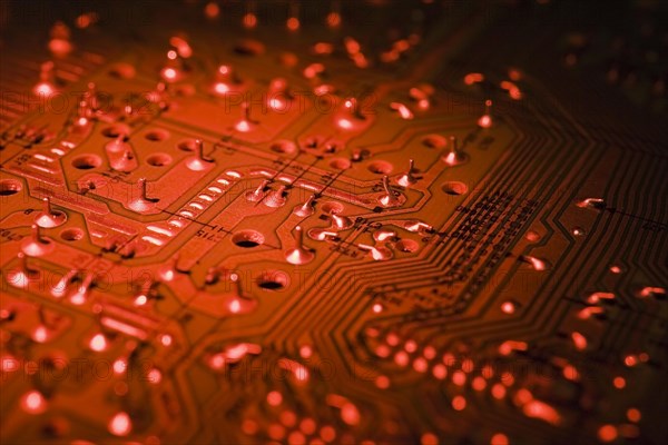 Close-up of red lighted electronic computer circuit board with silver solder points and lines, Studio Composition, Quebec, Canada, North America