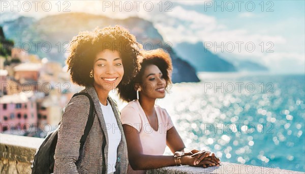 Relaxed pair of smiling women in casual-chic clothing enjoying time together, with a coastal town in the background, blurry moody landscaped background with bokeh effect, AI generated