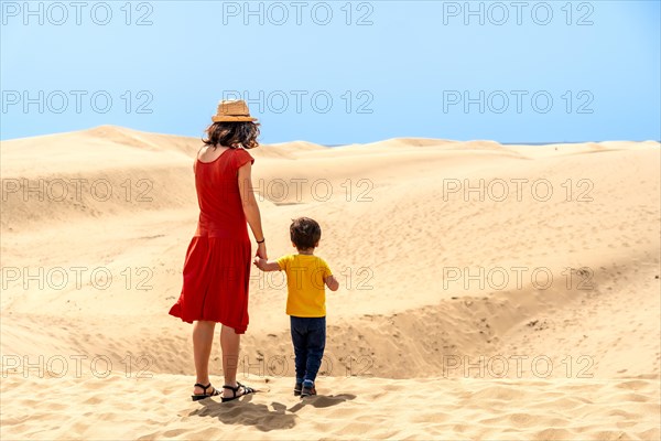 Mother and son on vacation very happy in the dunes of Maspalomas, Gran Canaria, Canary Islands