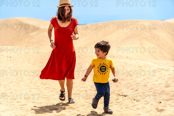 Mother and son on vacation smiling in the dunes of Maspalomas, Gran Canaria, Canary Islands