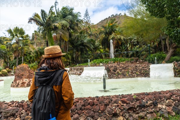 A woman enjoying and walking in a tropical botanical garden