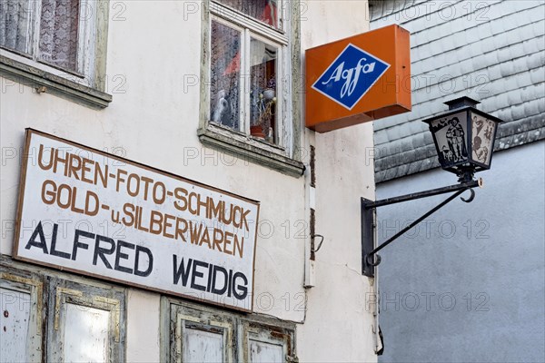 Cantilever sign, AGFA Film und Foto advertising sign, abandoned photo shop with watch shop, jewellery, gold and silver, shop sign, street lamp, dilapidated house, old town, Ortenberg, Vogelsberg, Wetterau, Hesse, Germany, Europe