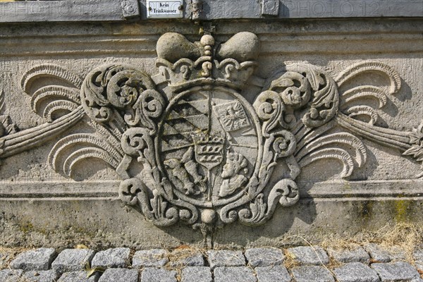 Coat of arms, stone relief on fountain, shield No drinking water, writing, letters, Winnental Castle built in the 15th century by the Teutonic Knights as the seat of the Winnender Kommende, former castle of the Teutonic Order, today Winnenden Castle Clinic Centre for Psychiatry, castle building, historical building, Winnenden, Rems-Murr district, Baden-Wuerttemberg, Germany, Europe