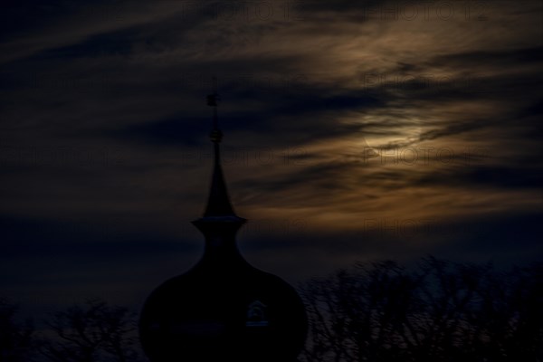 Full moon behind clouds above the steeple of the Protestant church in Braunschweig-Timmerlah, Braunschweig, Lower Saxony, Germany, Europe